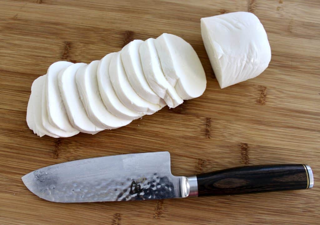 mozzarella cheese sliced on cutting board