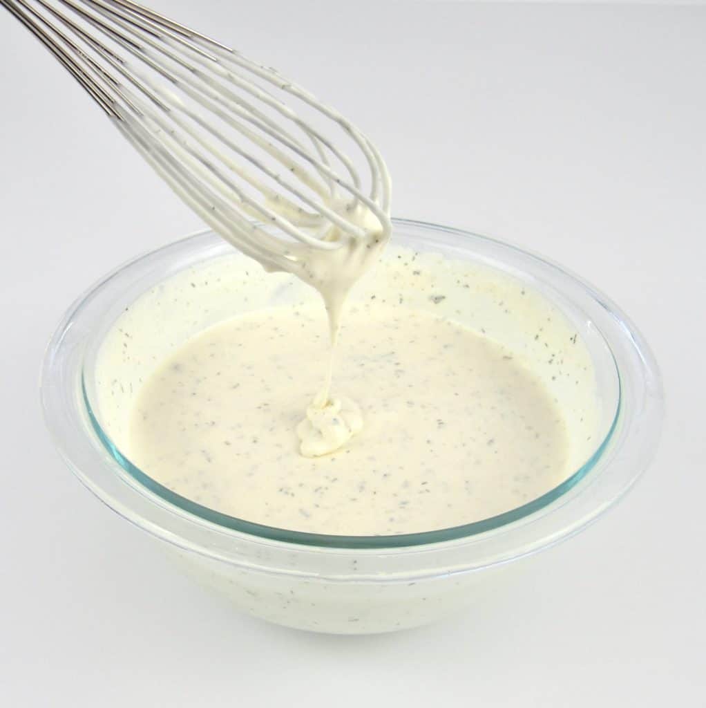 ranch dressing in glass bowl with whisk