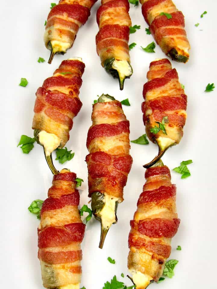 jalapeno poppers wrapped in bacon on white platter