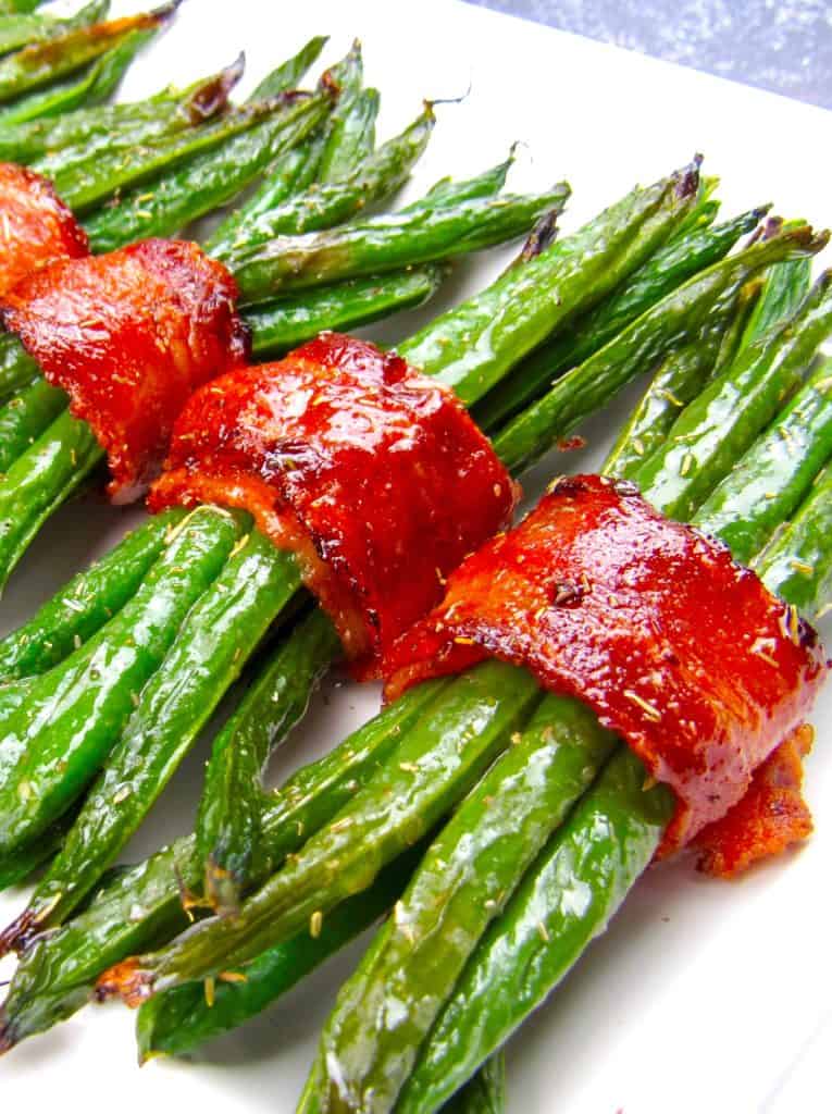 bacon wrapped green beans on white plate running caddy corner