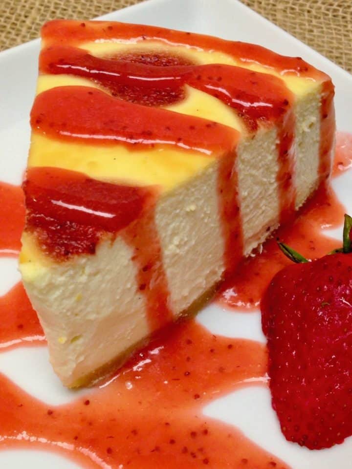 slice of cheesecake with strawberry sauce over the top