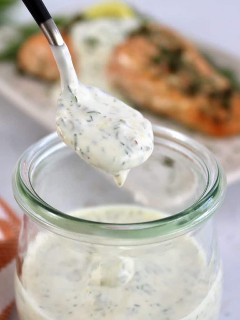 Creamy Dill Sauce being spooned out of glass jar