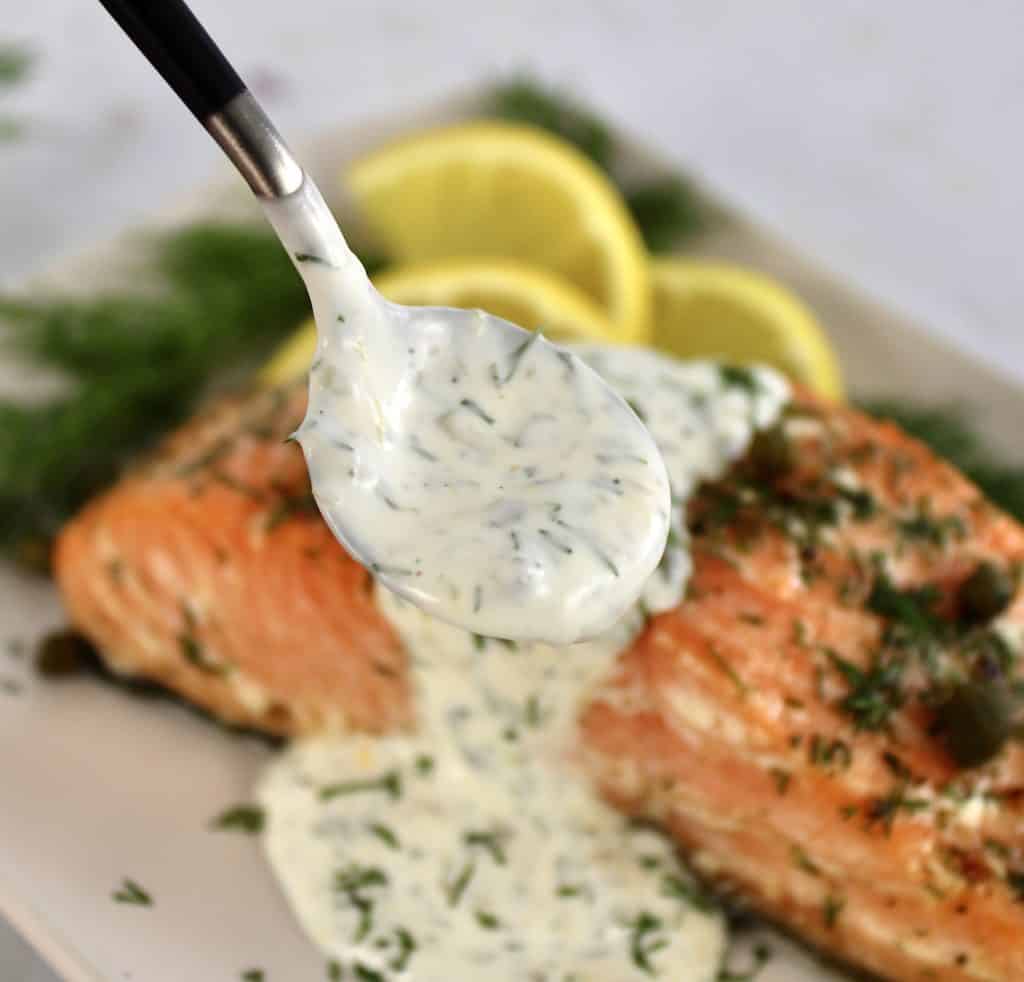 Creamy Dill Sauce being spooned over salmon