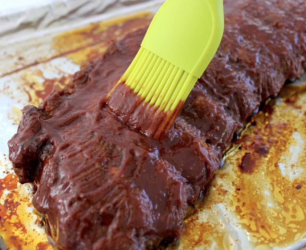 Keto Raspberry Chipotle BBQ Sauce being brushed over ribs