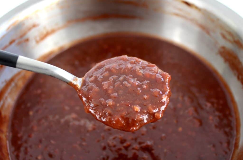 cooked Keto Raspberry Chipotle BBQ Sauce in saucepan with spoonful