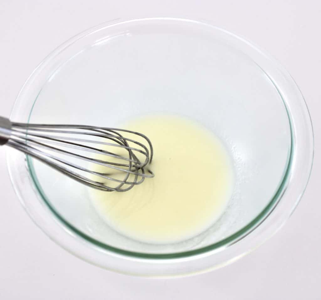lemon icing in glass bowl with whisk