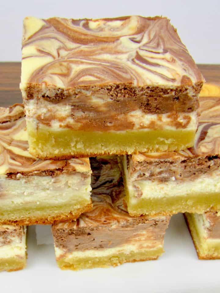 stack of vanilla chocolate swirl cheesecake bars on white plate