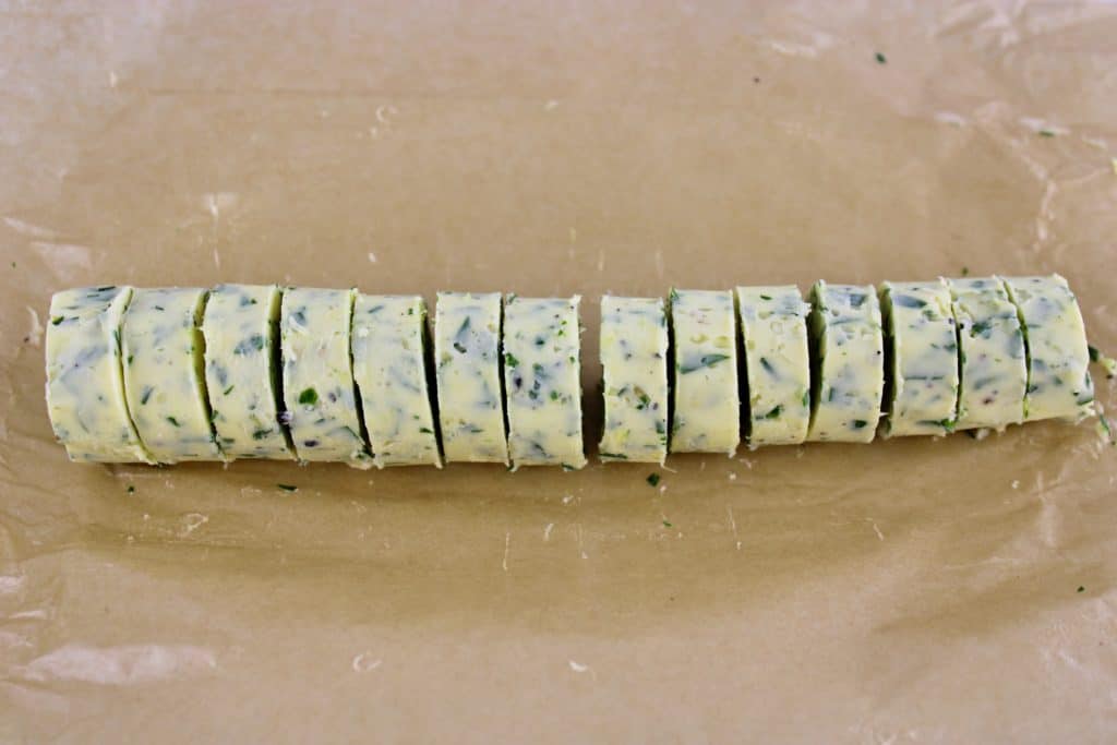 compound butter log sliced on parchment paper