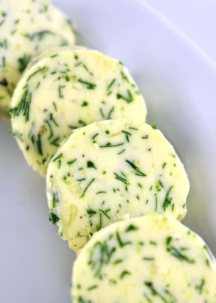 Garlic Herb Compound Butter in discs on white plate