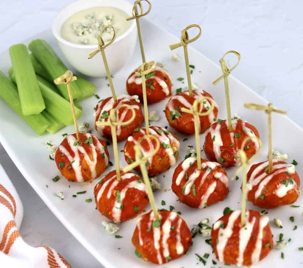Keto Buffalo Chicken Meatballs on white platter with fancy toothpicks