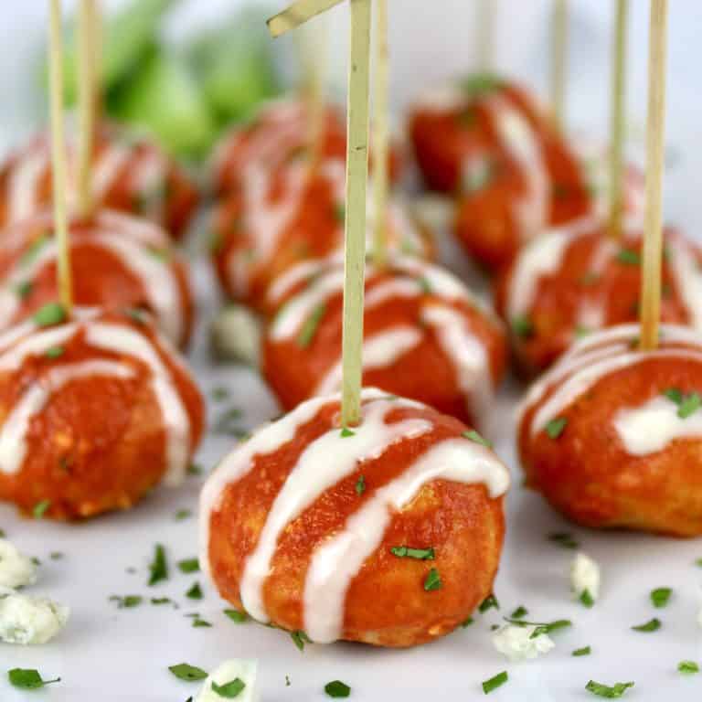 Keto Buffalo Chicken Meatballs on white platter with fancy toothpicks