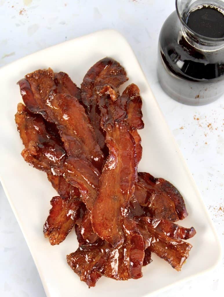 candied bacon with maple syrup in background