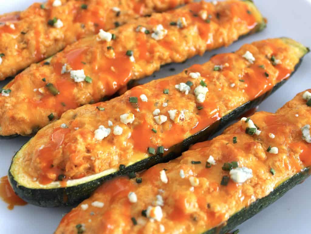 Buffalo Chicken Zucchini Boats with blue cheese and wing sauce drizzled on top