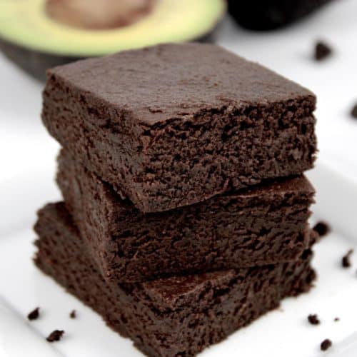 chocolate avocado brownies stacked up on white plate