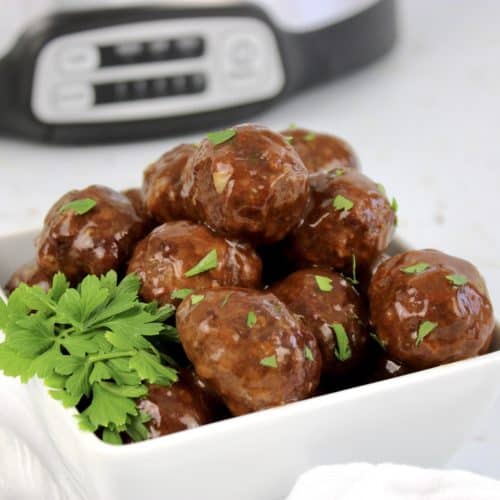 crockpot bbq meatballs in white bowl with crockpot in background