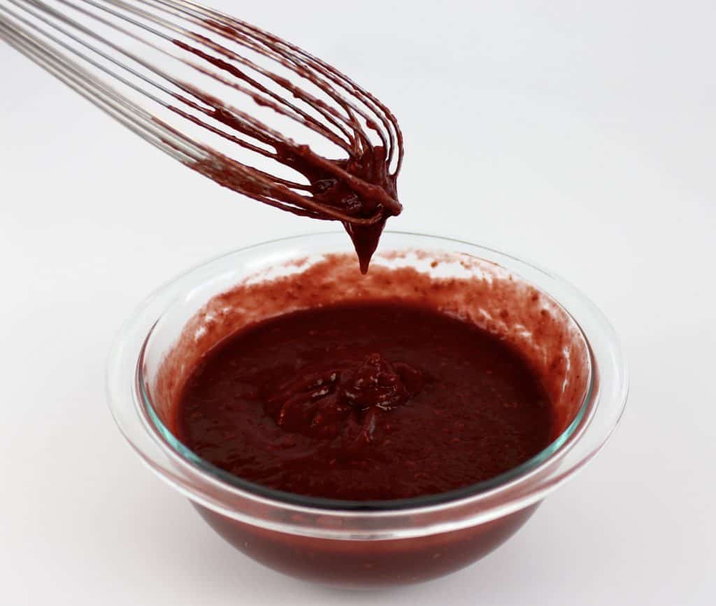 raspberry bbq sauce in glass bowl with whisk