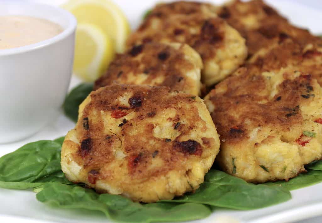 closeup of crab cakes on bed of spinach