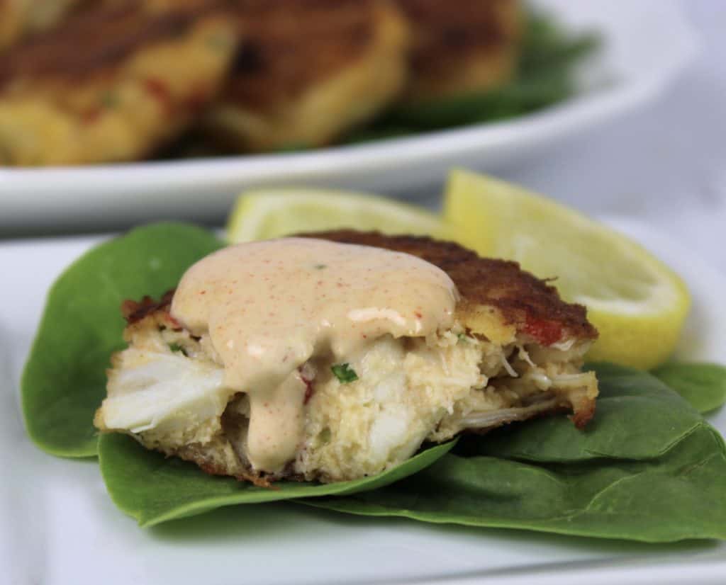 closeup of crab cake with remoulade on top