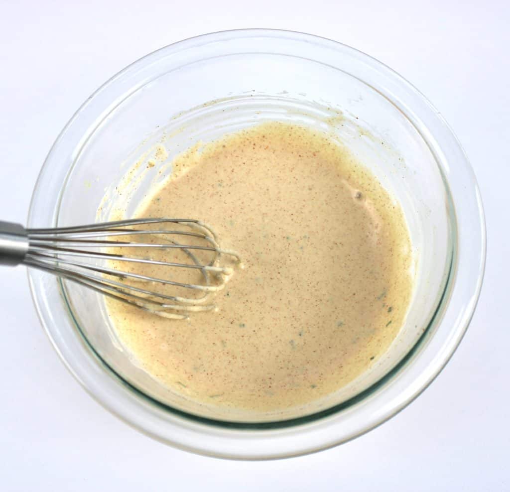 remoulade sauce in glass bowl with whisk