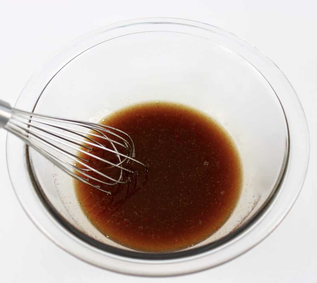 maple glaze sauce in glass bowl with whisk