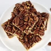 overhead view of pecan pie bars stacked up on white plate