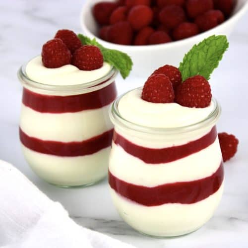white chocolate mousse with raspberry sauce layers in two glass jars