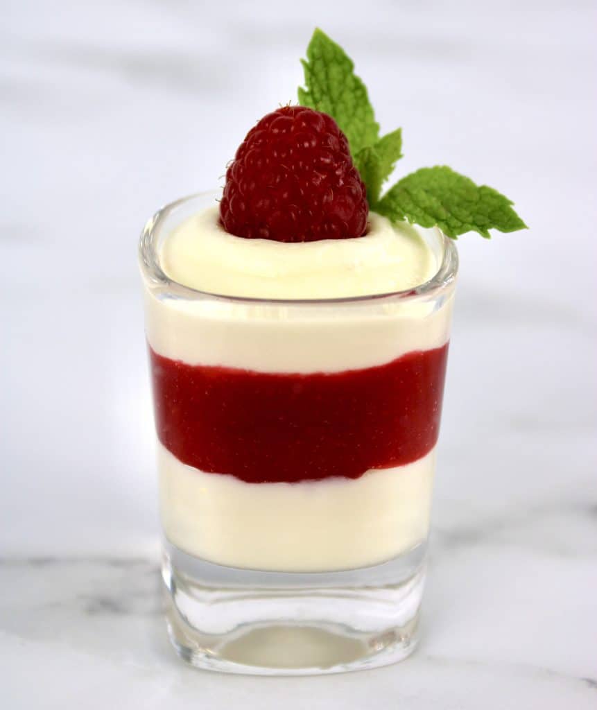 white chocolate mousse with raspberry sauce layers in shot glass