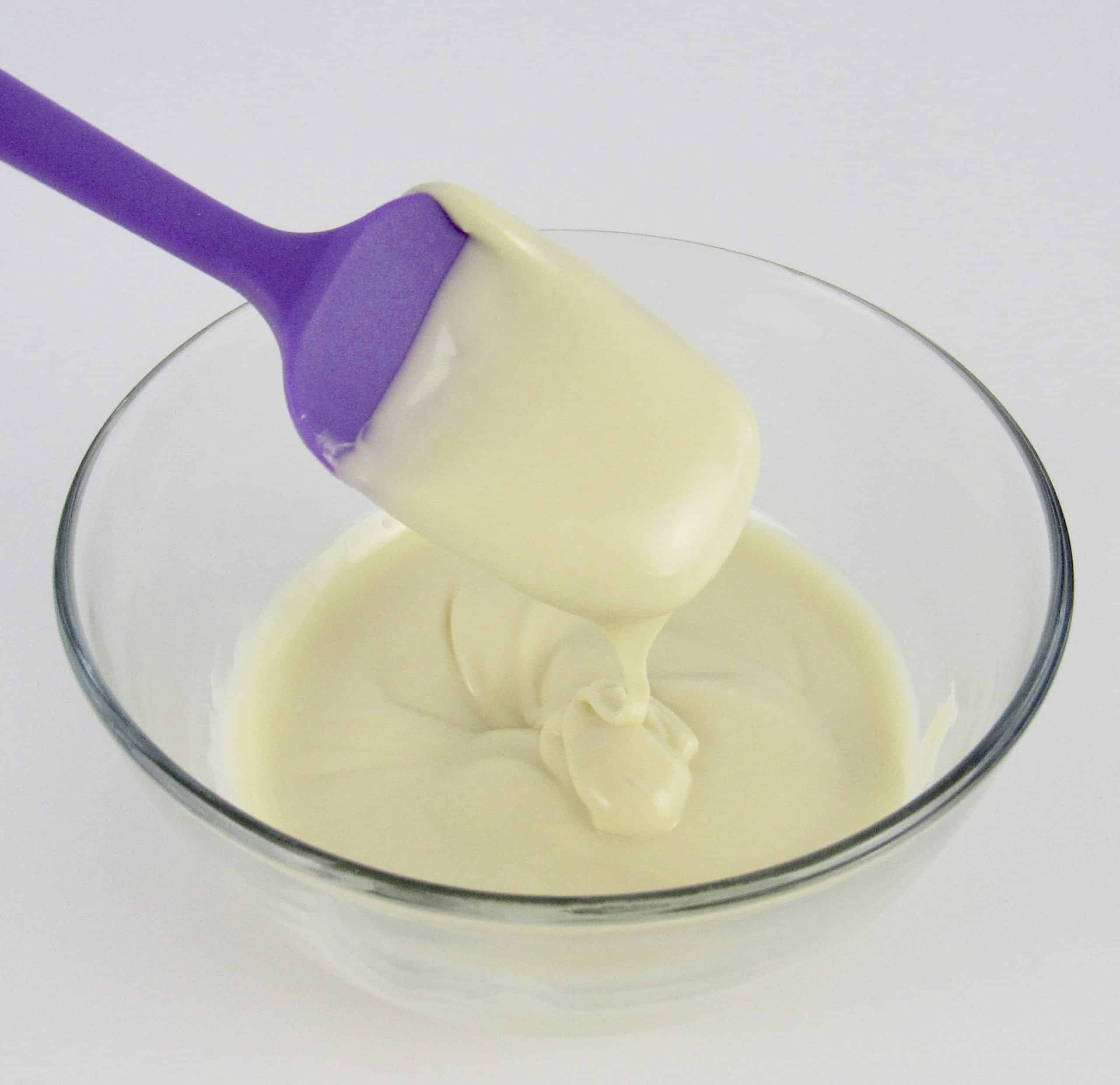 melted white chocolate in glass jar with silicone spoon