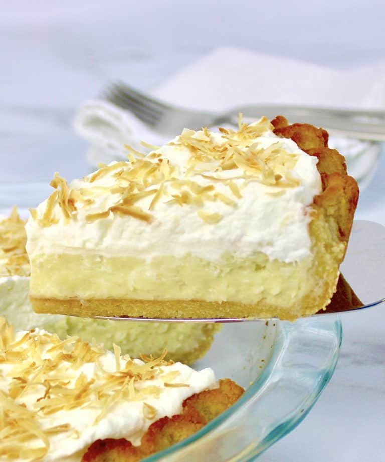 closeup of Coconut Cream Pie slice with pie in background