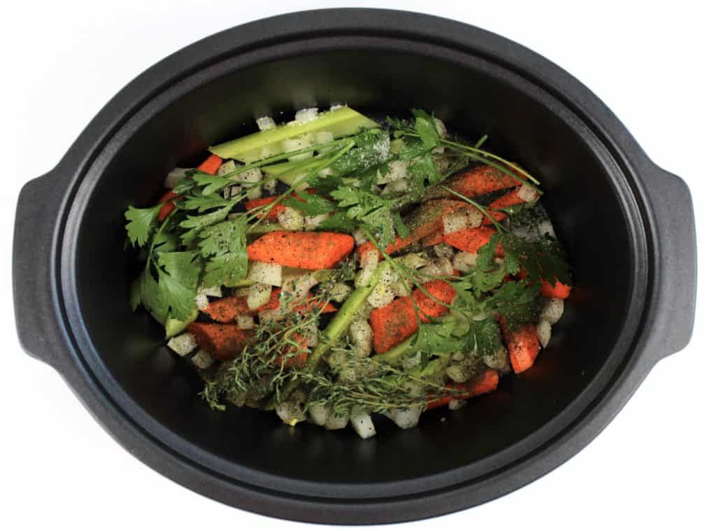 carrots celery and herbs in crockpot