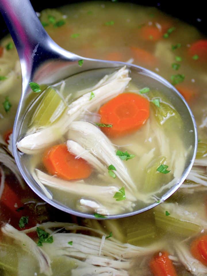 chicken soup in crockpot with silver ladle