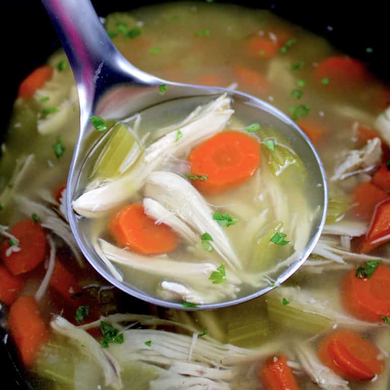 chicken soup in crockpot with silver ladle