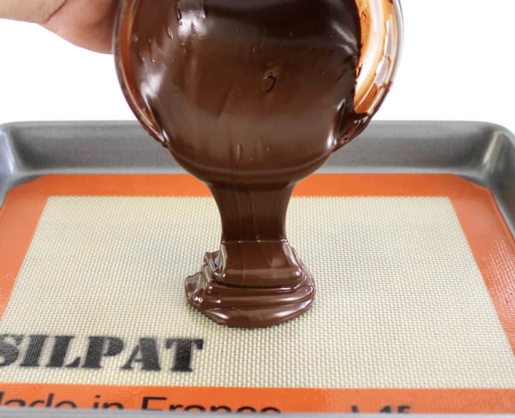 melted chocolate being poured onto Silpat