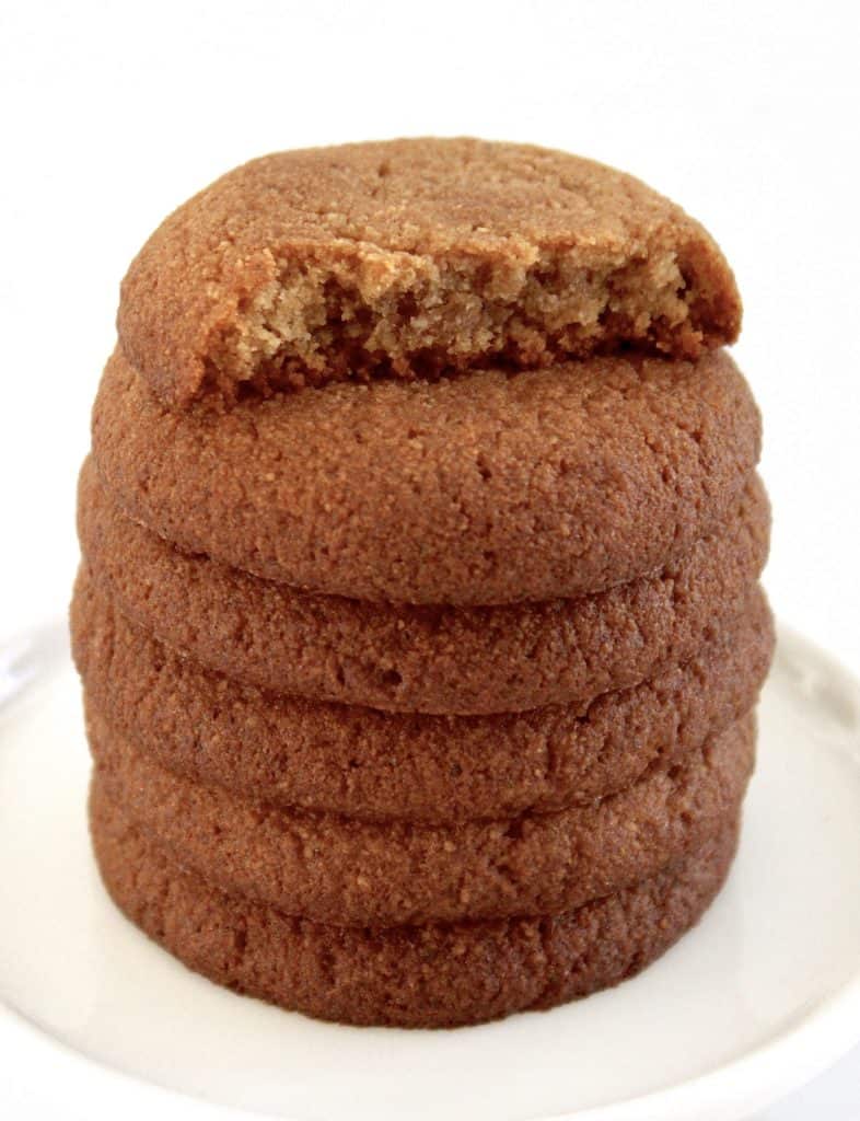 stack of gingerbread cookies with bite taken out of the top cookie