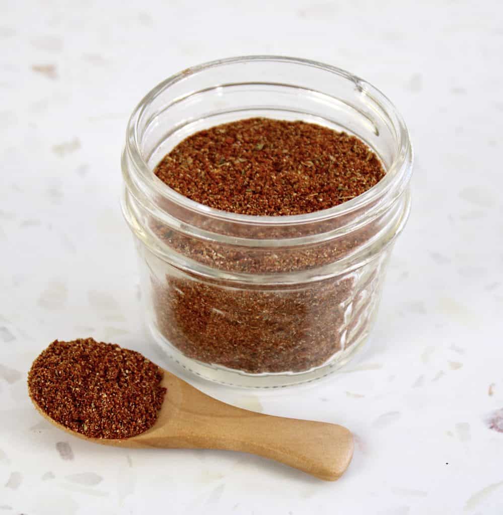 taco seasoning in glass jar with spoonful on side