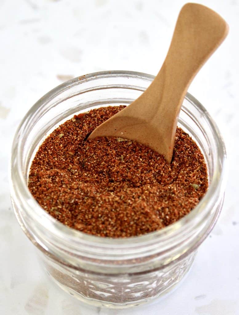 taco seasoning mix in glass jar with wooden spoon