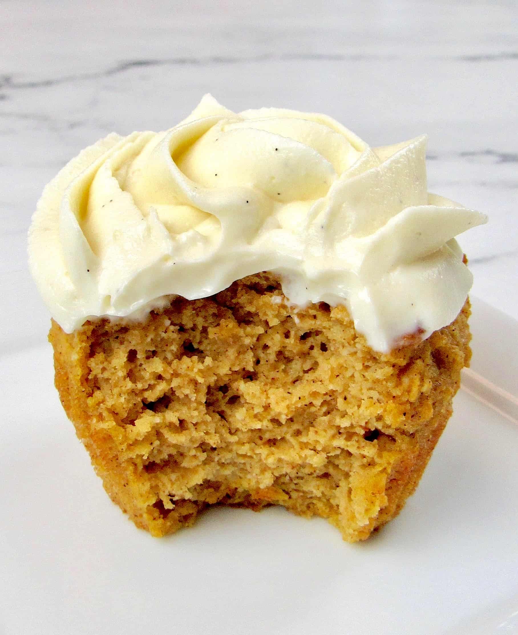 Pumpkin Cupcake with vanilla icing and bite missing