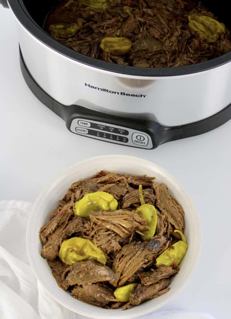 mississippi pot roast in bowl with peppers crockpot in background