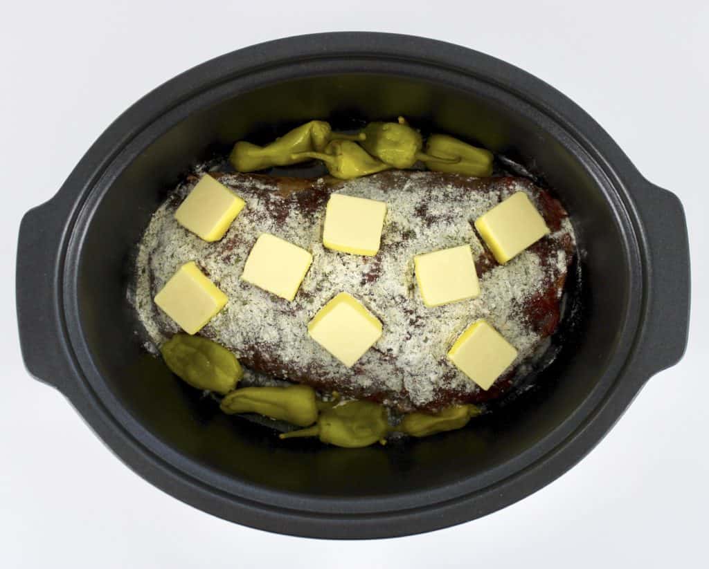 pot roast with spices, peppers and butter pads on top