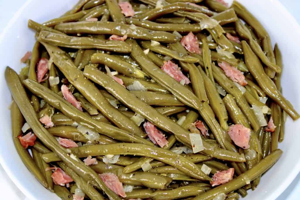 closeup of cooked green beans and chunks of ham