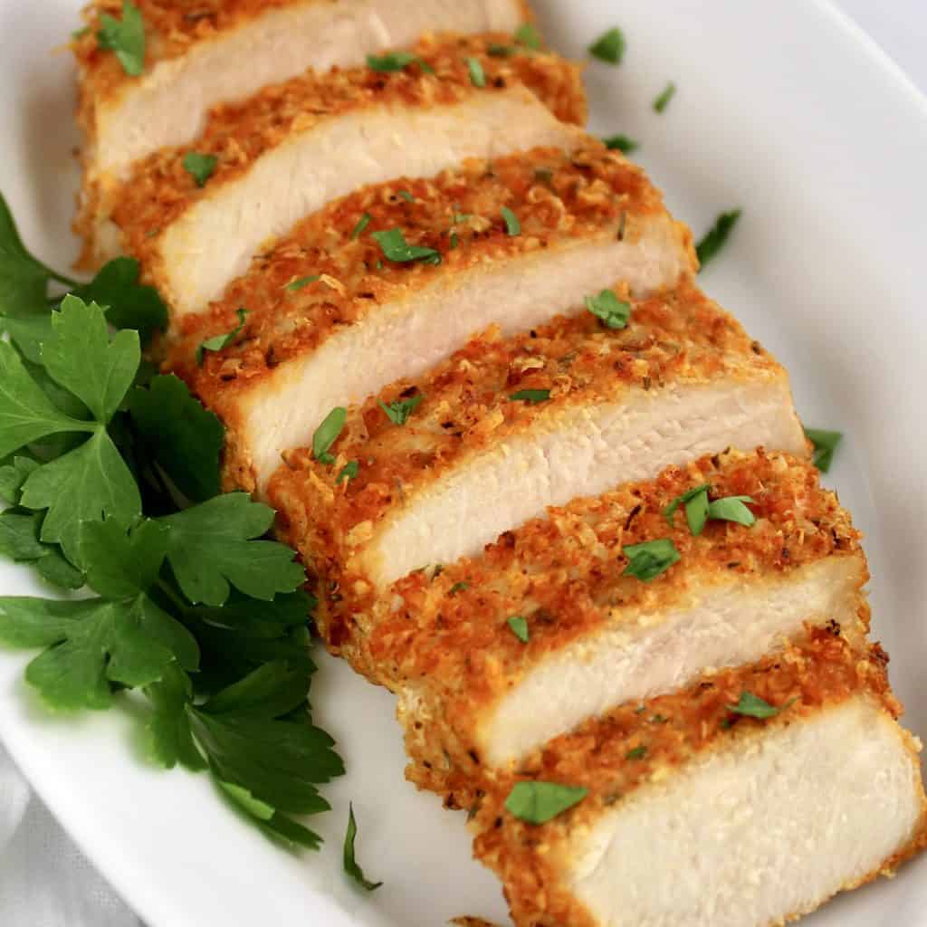 air fryer pork chop sliced on plate with parsley on side