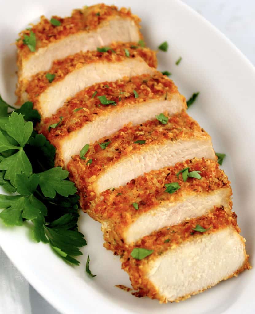 air fryer pork chop sliced on plate with parsley on side