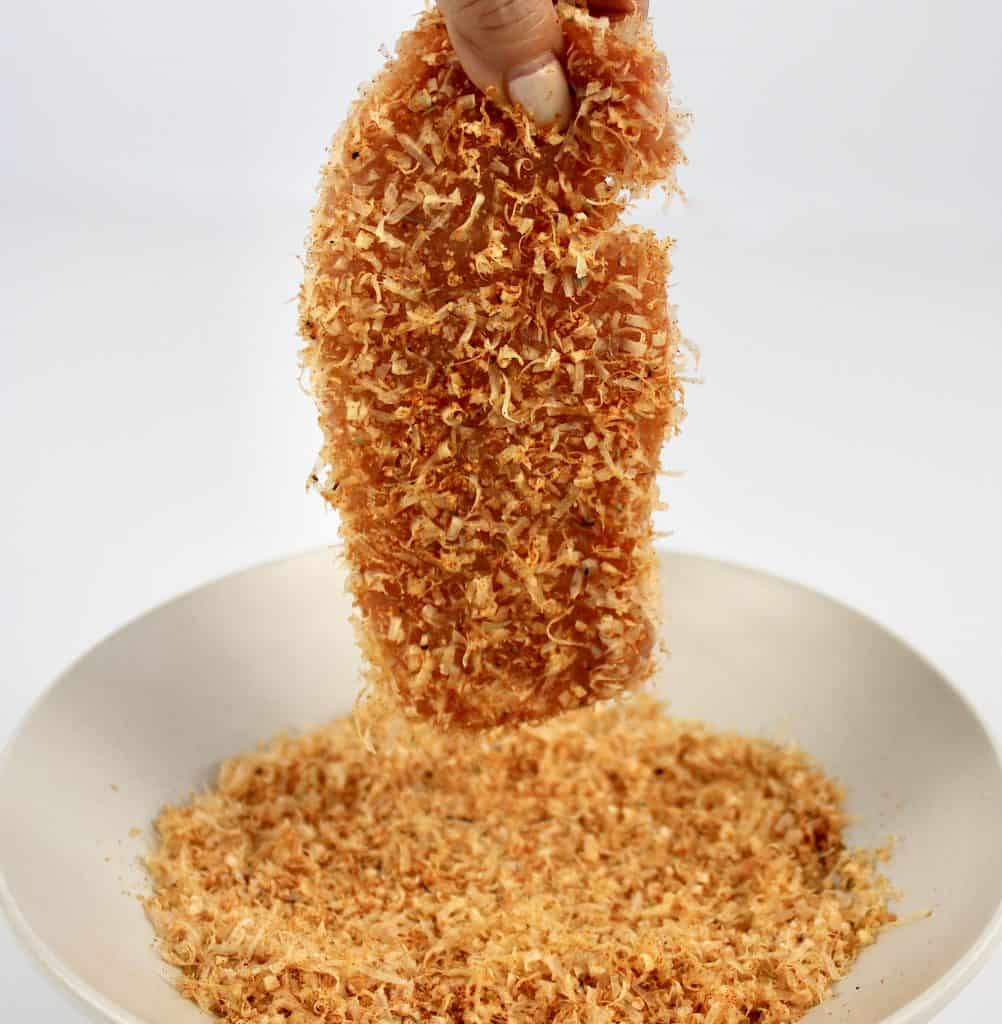 pork chop being dipped into breading