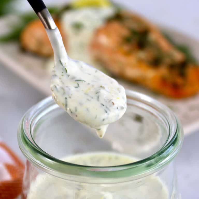 Creamy Dill Sauce being spooned out of glass jar