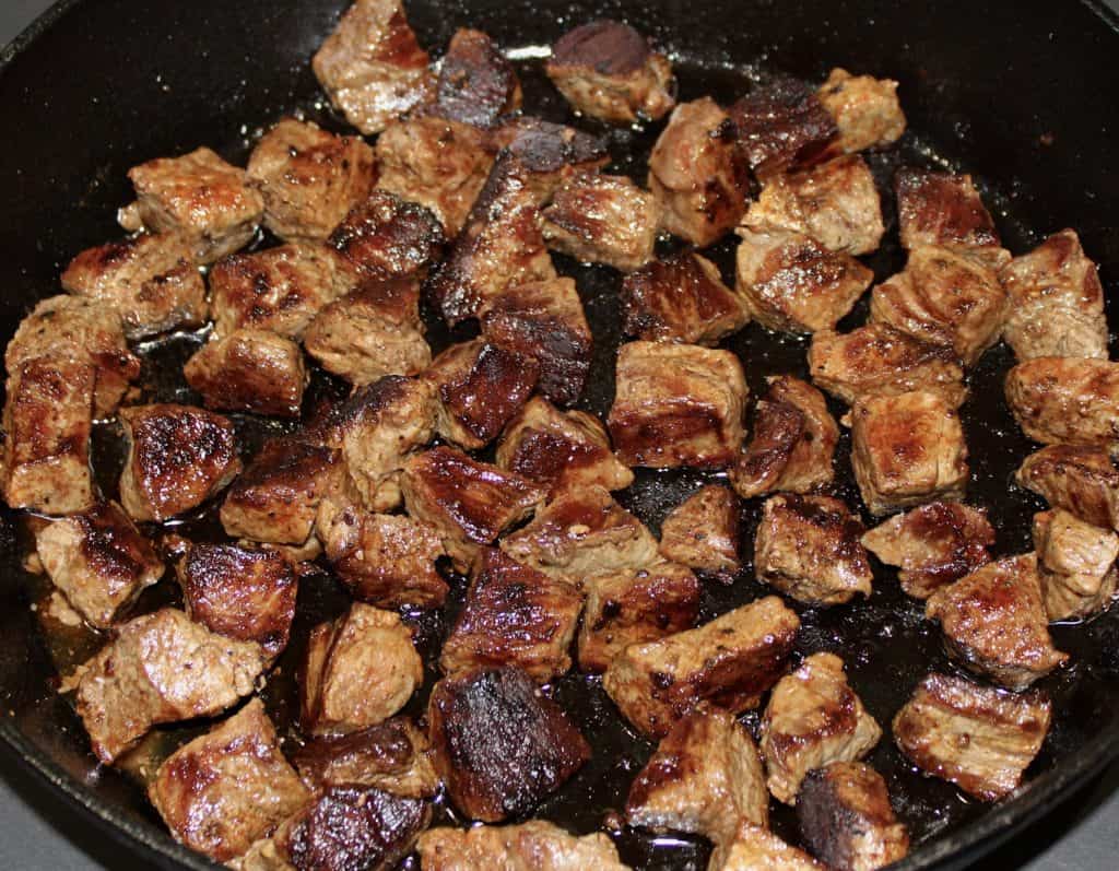cooked steak chunks in skillet