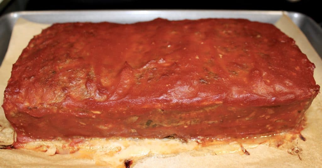 meatloaf covered in ketchup on baking sheet