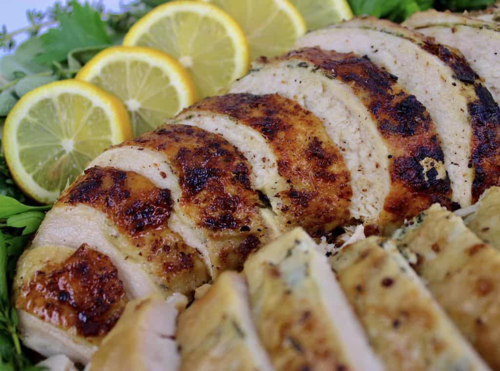 closeup of sliced turkey breast with slices of lemon