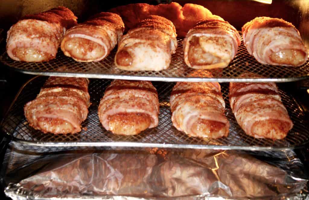 bacon wrapped chicken tenders inside air fryer on racks