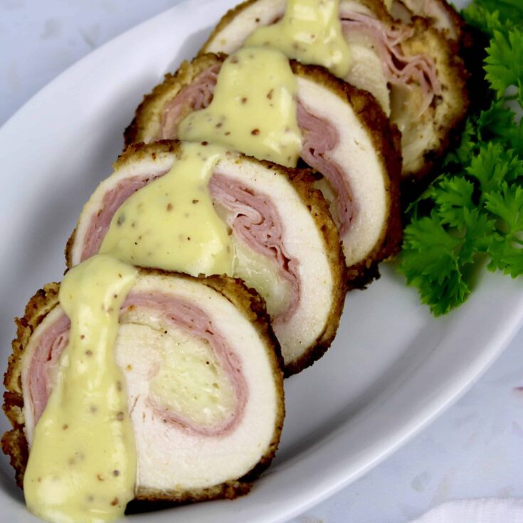 slices of chicken cordon bleu with mustard sauce on top