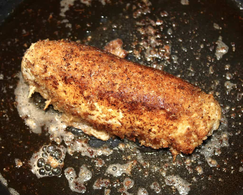 cooked breaded chicken breast in skillet